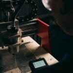 Operator obsługuje maszynę CNC w słabo oświetlonym pomieszczeniu