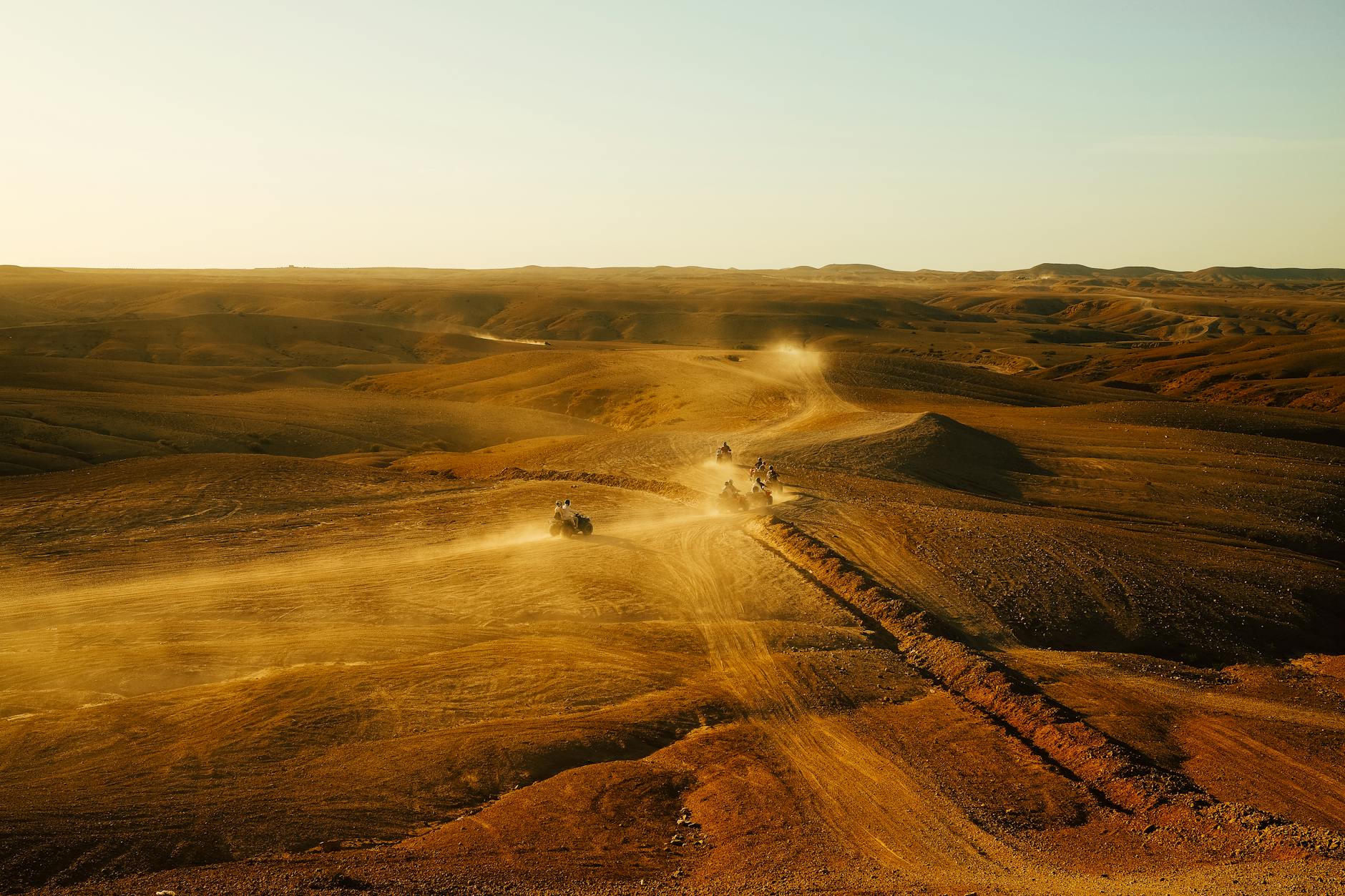 Quady jadą po pustyni o zachodzie słońca