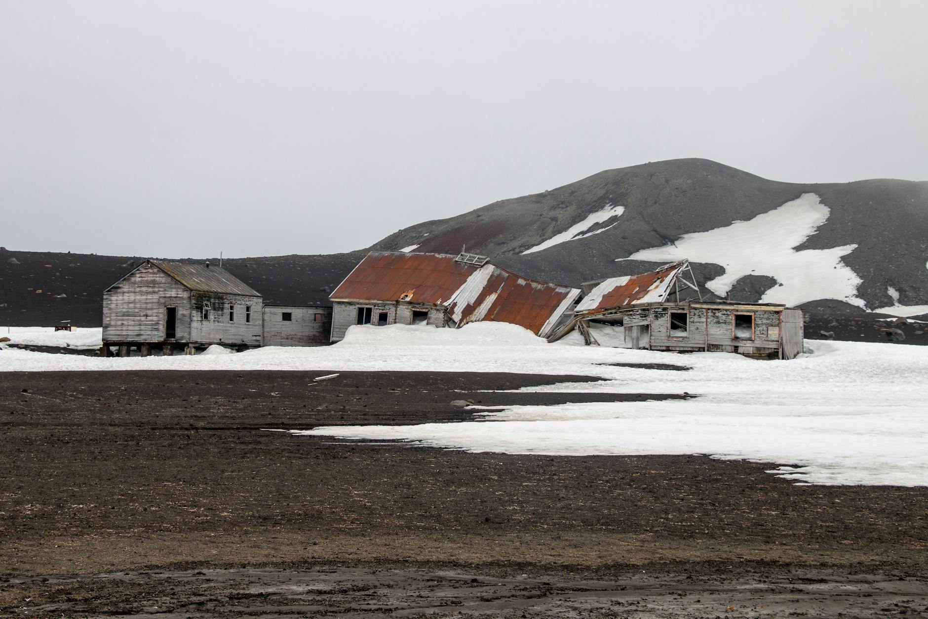 Ruiny stacji wielorybniczej w antarktycznym lodowo-wulkanicznym krajobrazie