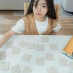 Dziecko gra w grę karcianą wymagającą koncentracji w domu