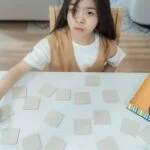 Pamięć robocza: jak ją wspierać i czego nie obiecują treningi „brain games” Dziecko gra w grę karcianą wymagającą koncentracji w domu