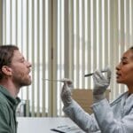 Lekarz bada gardło pacjenta w gabinecie podczas profilaktycznego badania