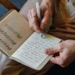 Pytania od czytelników: dlaczego pamiętam teksty piosenek, a nie materiał z lekcji? Mężczyzna zapisuje tekst piosenki i nuty w notesie