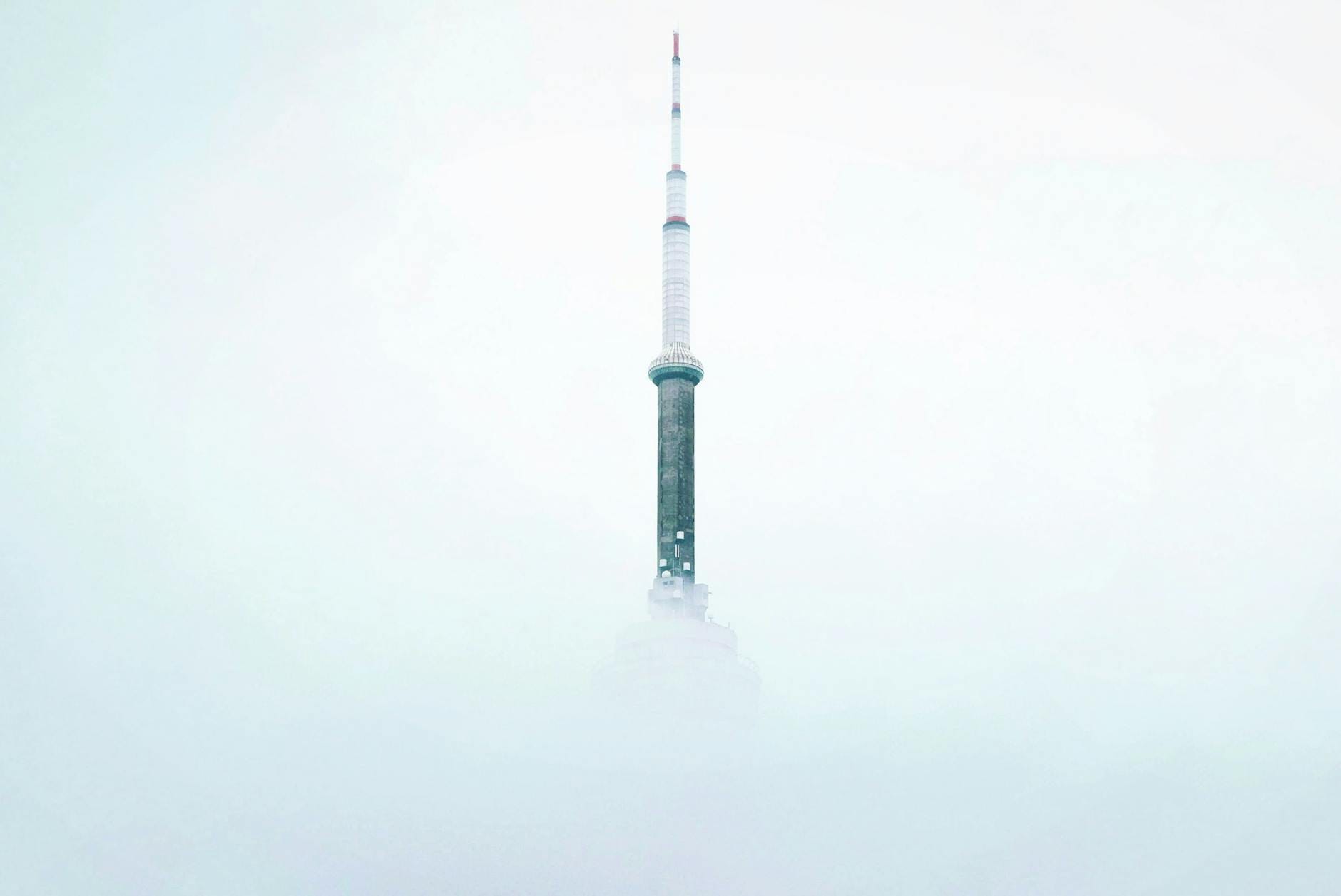 Wieżowiec o nowoczesnej architekturze wyłaniający się z gęstej mgły