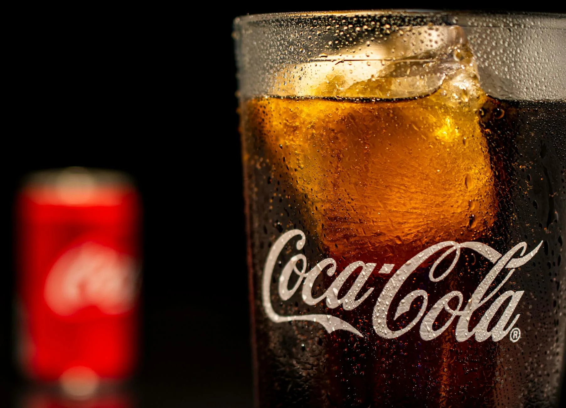 Chemia bąbelków: skąd bierze się gaz w napojach i czemu ucieka po otwarciu? Zbliżenie szklanki coli z lodem i bąbelkami gazu