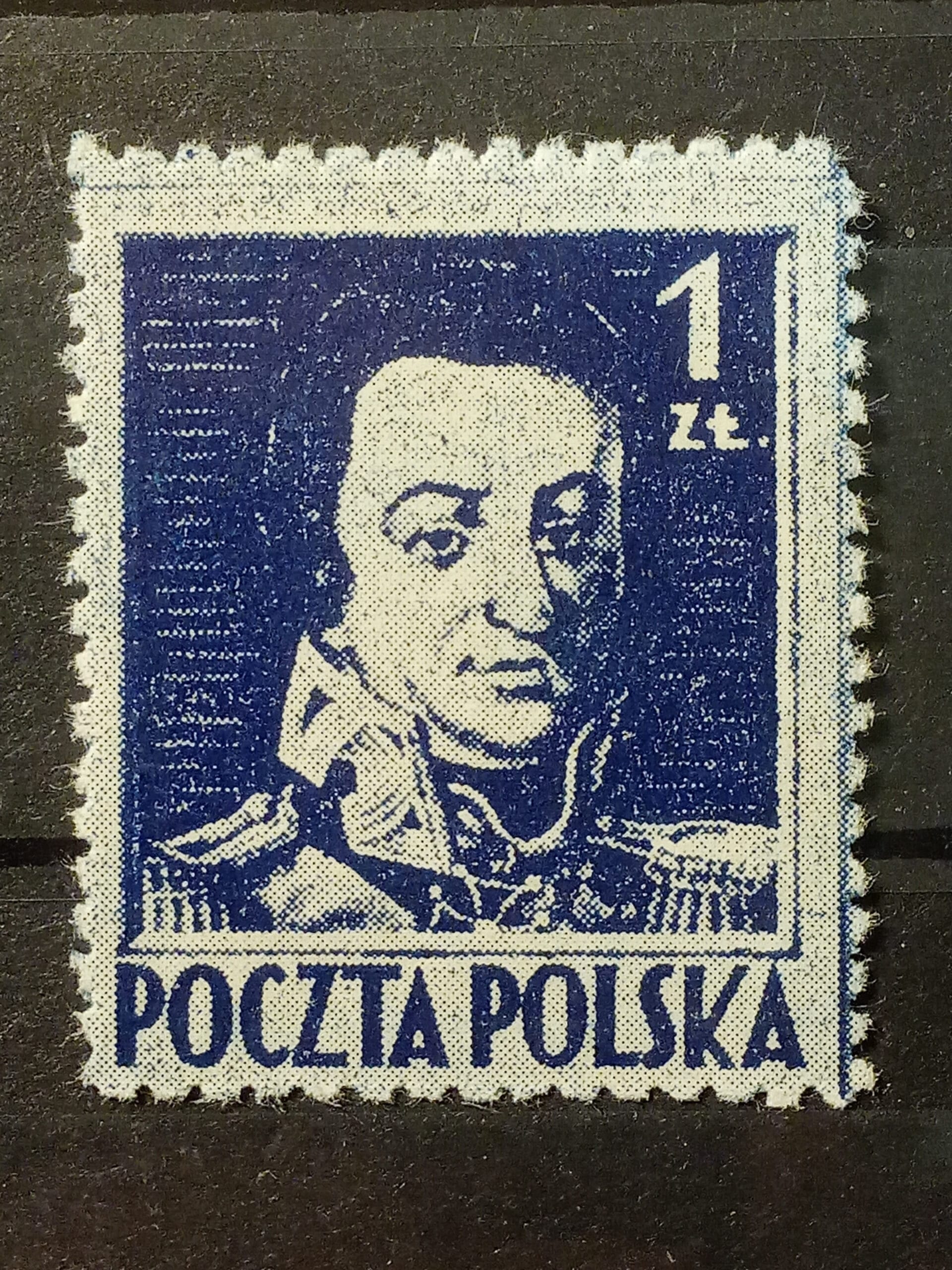 Makrofotografia krawędzi znaczka ukazująca precyzyjne, gęste ząbkowanie i strukturę papieru