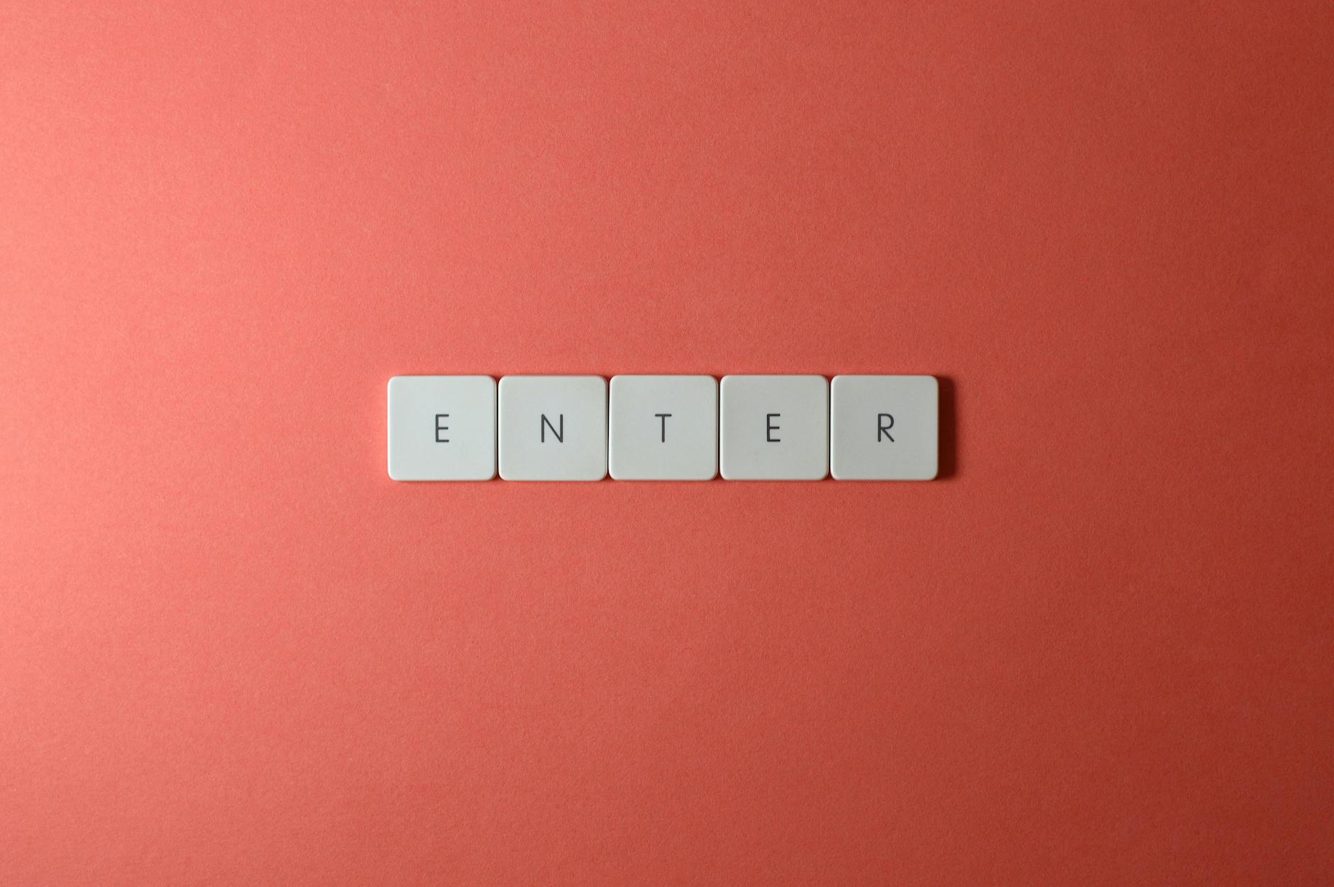 Klawisze z napisem ENTER na tle w kolorze koralowym