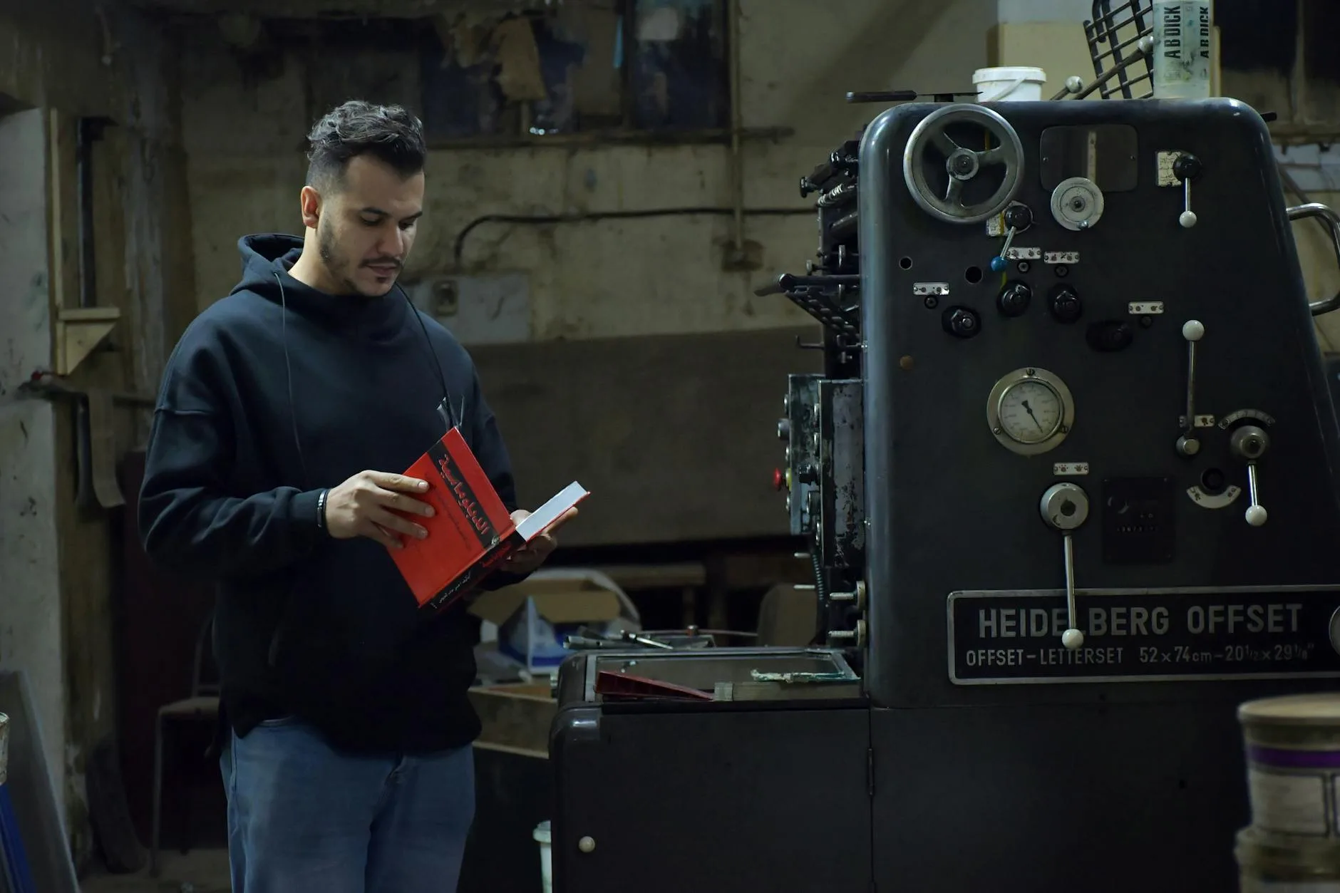 Czy offset CO2 działa, czy to greenwashing? Jak oceniać projekty kompensacji Mężczyzna w czarnej bluzie przy przemysłowej maszynie drukarskiej