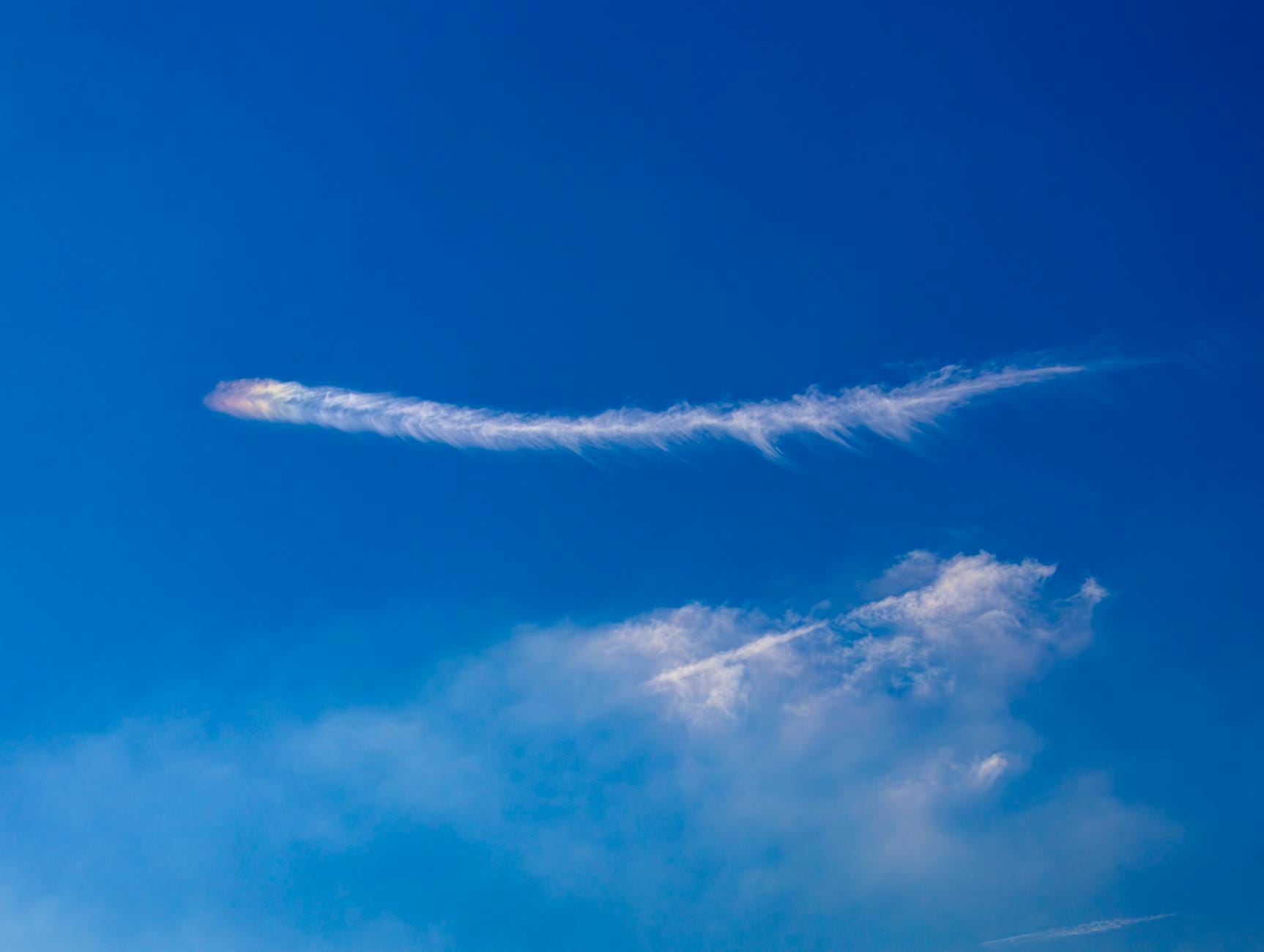 Ślad meteoru na jasnoniebieskim niebie podczas spalania w atmosferze