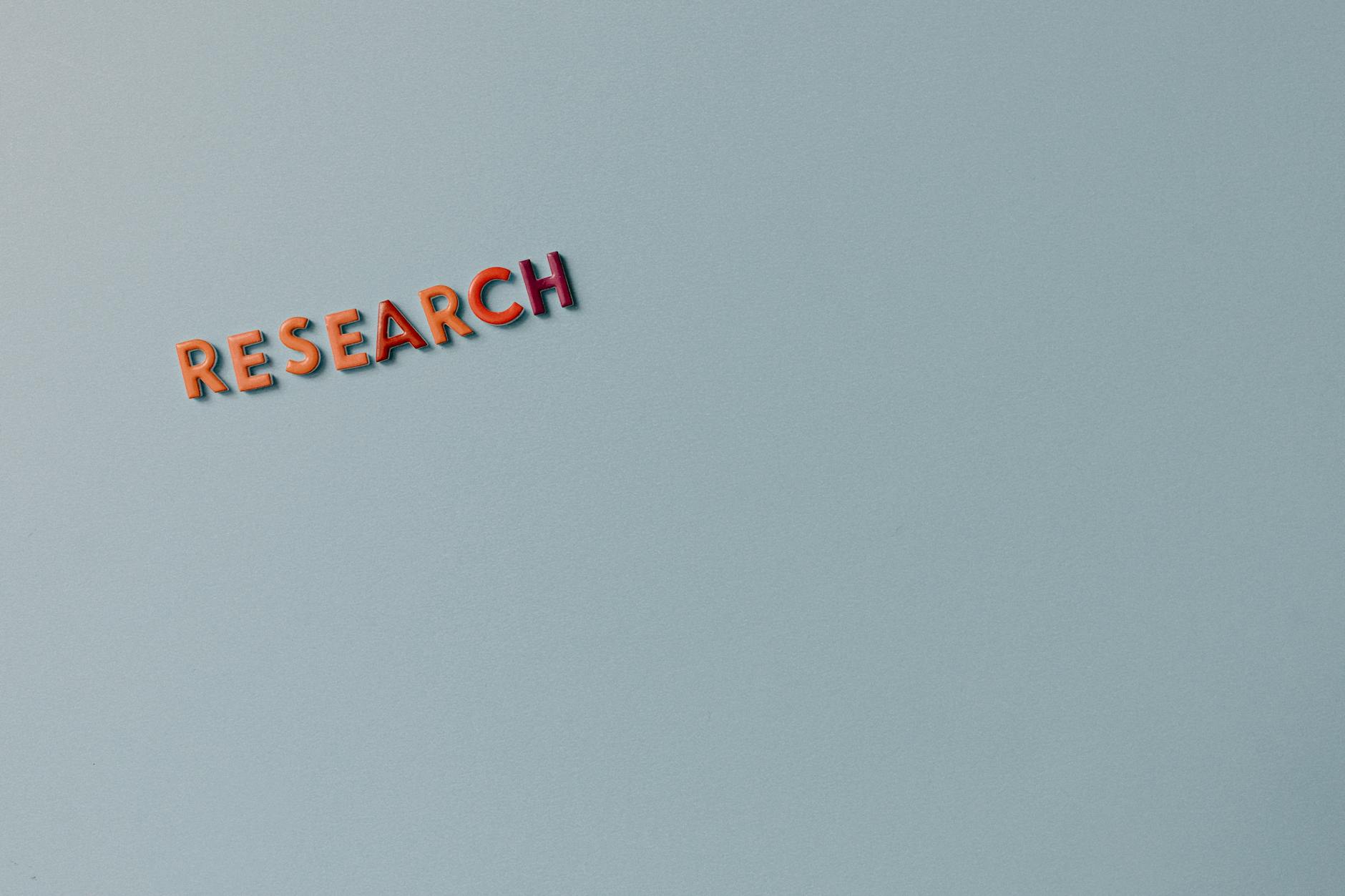 Napis research z kolorowych liter na jasnym, minimalistycznym tle