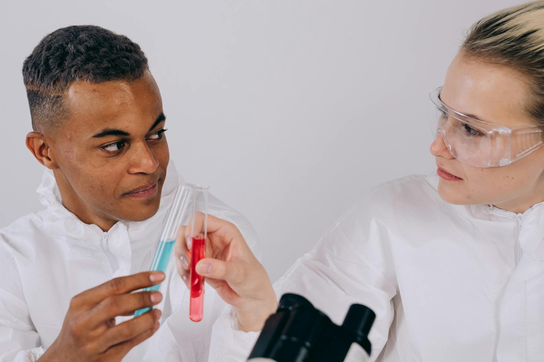 Dwóch naukowców w fartuchach analizuje probówki w laboratorium