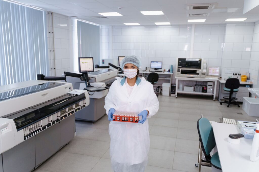 Naukowiec w odzieży ochronnej trzyma próbki w nowoczesnym laboratorium